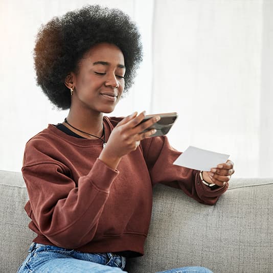 African woman taking photo of healthcare treatment receipt
