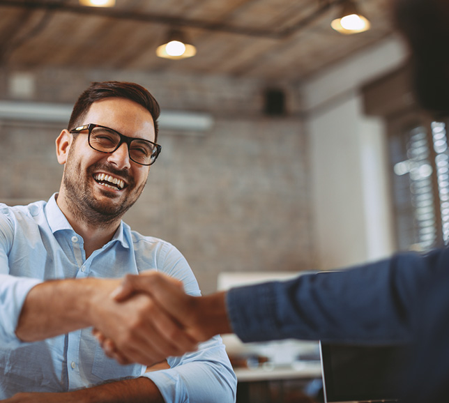 Man smiling and shaking hands with a client