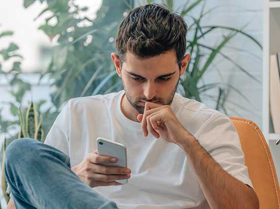 Man anxiously looking up symptoms on mobile phone
