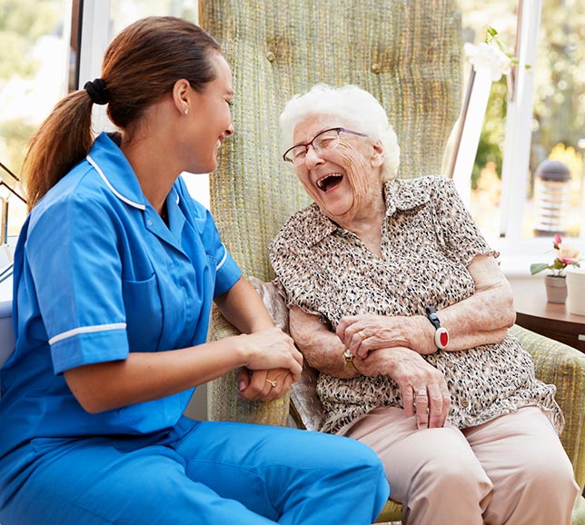 Nurse laughing and smiling with an elderly patient