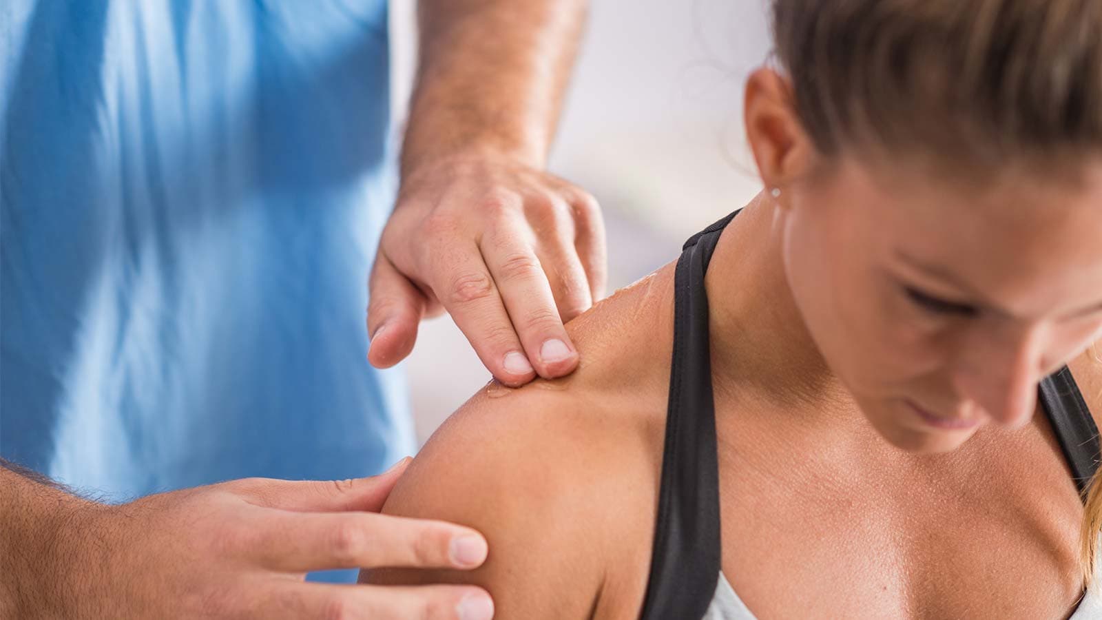 Osteopath looking at patients trapezius muscle