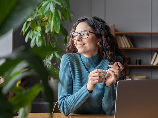 Woman sat at home office desk and smiling