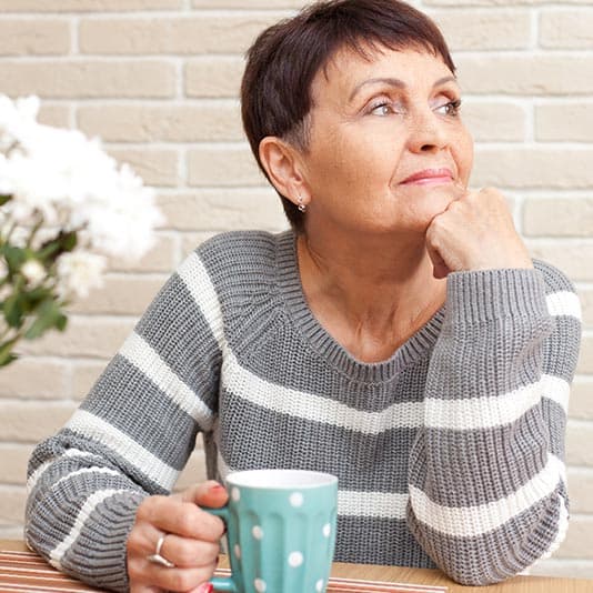 Woman with mug looking into distance